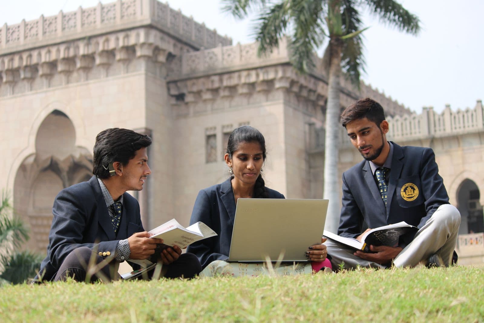 Students in India studying together with books and a laptop